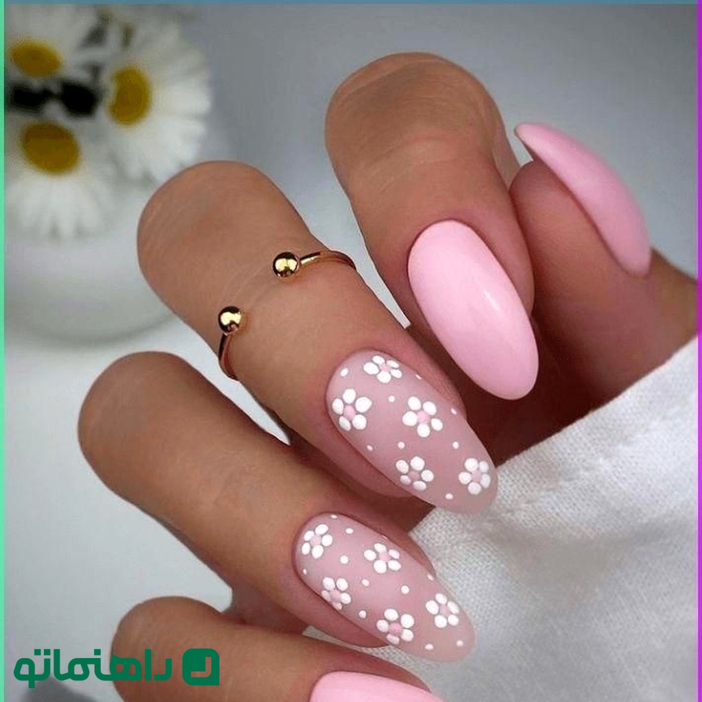 2. مدل ناخن بادامی با زمینه صورتی ملایم و گل‌های سفید کوچک