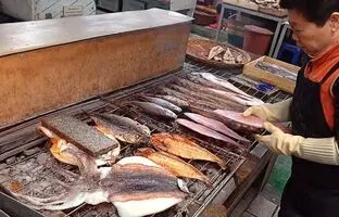 (ویدئو) غذای خیابانی؛ مردم سئول برای ماهی کبابی این آشپز زن مسن صف می‌کشند
