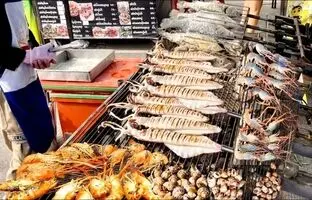 (ویدئو) غذاهای خیابانی؛ مشهورترین ماهی و میگوی کبابی را این فروشنده در بانکوک آماده می کند