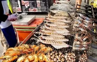 (ویدئو) غذاهای خیابانی؛ مشهورترین ماهی و میگوی کبابی را این فروشنده در بانکوک آماده می کند