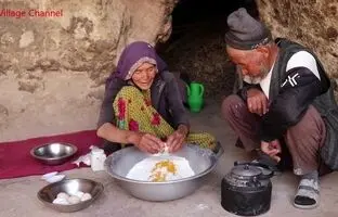 (ویدئو) پخت نان روی ساج و کباب کردن تخم مرغ توسط زوج مسن افغانستانی در غار باستانی