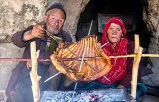 (ویدئو) کباب کردن 2 کیلوگرم دنده گوسفند به سبک زوج مسن غارنشین افغانستانی