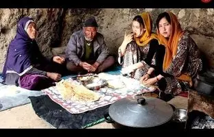 (ویدئو) پخت یک غذای محلی با بادمجان و گوجه روی ذغال توسط دختران غارنشین افغانستانی