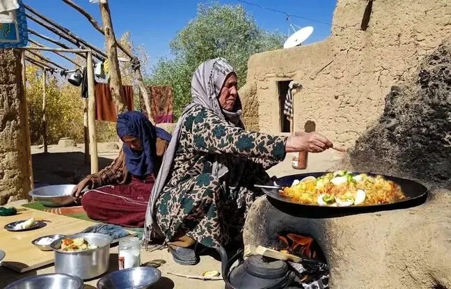(ویدئو) پخت یک غذای محلی با کلم، گوجه و سیب زمینی روی ساج توسط دو زن روستایی افغانستانی