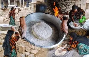 (ویدئو) پخت یک نان سنتی زیر خاکستر و ذغال توسط یک کدبانوی روستایی ایرانی