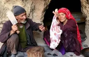 (ویدئو) کباب کردن ران 3 کیلوگرمی گوسفند توسط زوج مسن افغانستانی که در غار زندگی می کنند