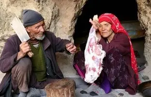 (ویدئو) کباب کردن ران 3 کیلوگرمی گوسفند توسط زوج مسن افغانستانی که در غار زندگی می کنند