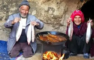 (ویدئو) طبخ ماهی محلی توسط عاشقان مسن قدیمی افغانستانی در یک غار باستانی