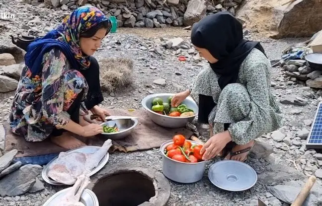 (ویدئو) غذاهای روستایی: پخت یک غذای متفاوت با ران گوسفند توسط دو بانوی عشایری افغانستانی