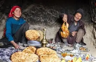(ویدئو) پخت تماشایی نان سنتی و مرغ در تنور به سبک زوج مسن غارنشین افغانستانی