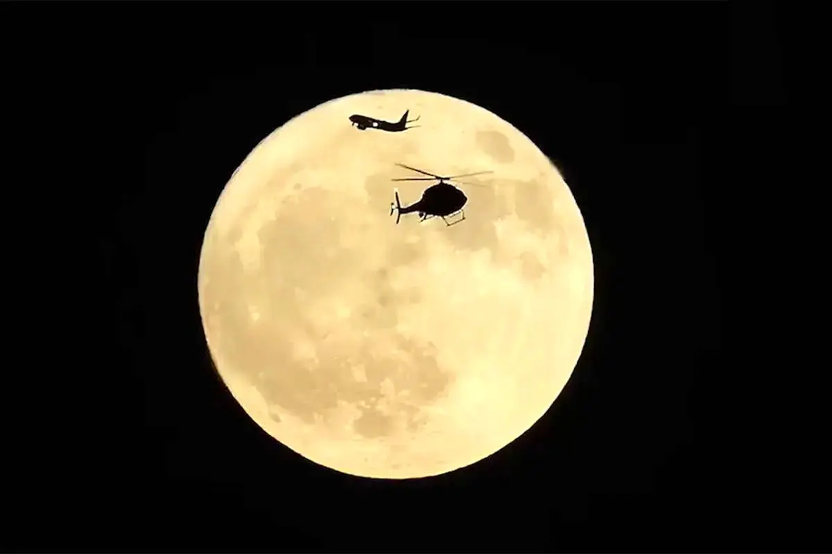  لحظه خیره‌کننده‌ عبور همزمان بالگرد و هواپیما از مقابل «ماه توت‌فرنگی» + ویدئو