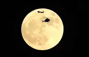  لحظه خیره‌کننده‌ عبور همزمان بالگرد و هواپیما از مقابل «ماه توت‌فرنگی» + ویدئو